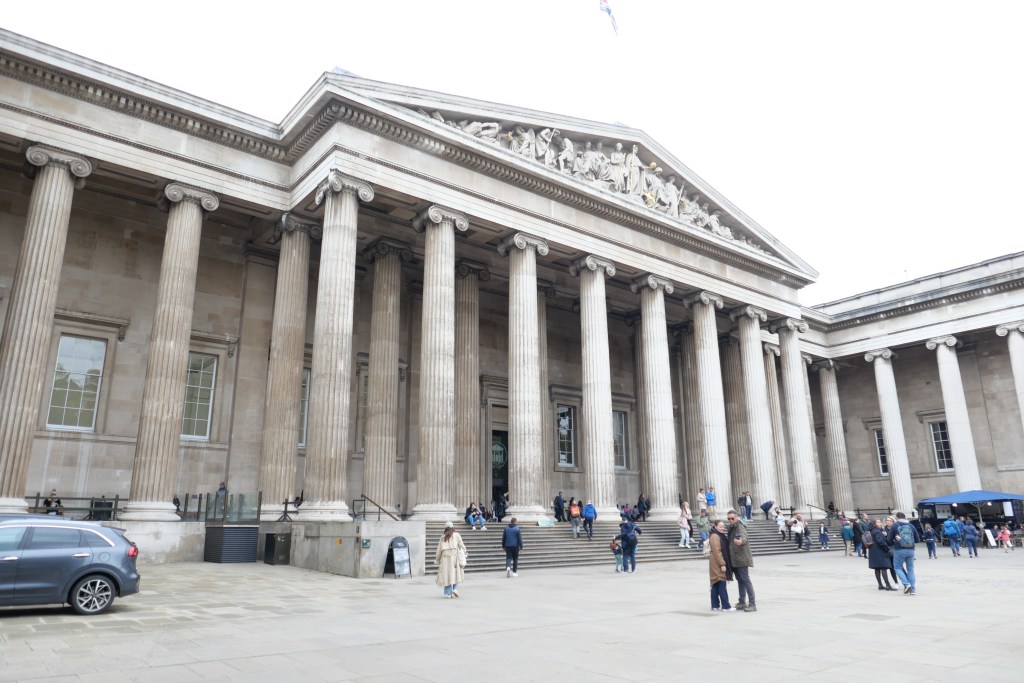 大英博物館の外観、柱が立ち並び、訪れる人々がいる光景。